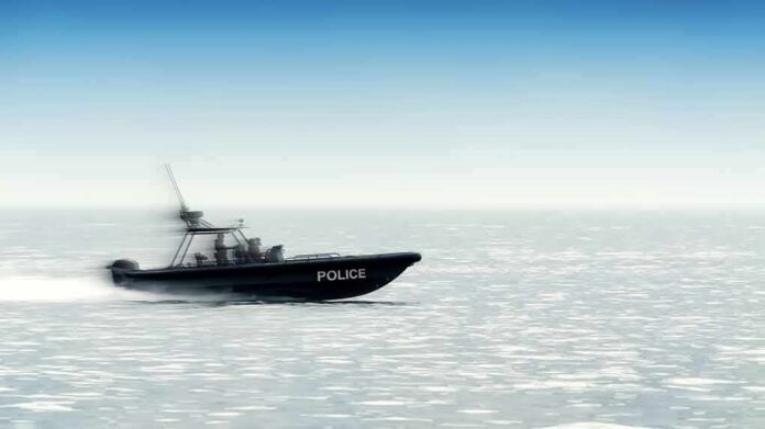 shutterstock_1253930197 Police patrol boat speeding across open water
