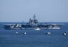 Hormuz Flashpoint: U.S. Drones Shot Down Aircraft carrier at sea with small boat alongside