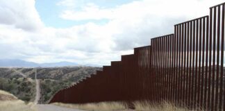 Border fence along a hilly landscape