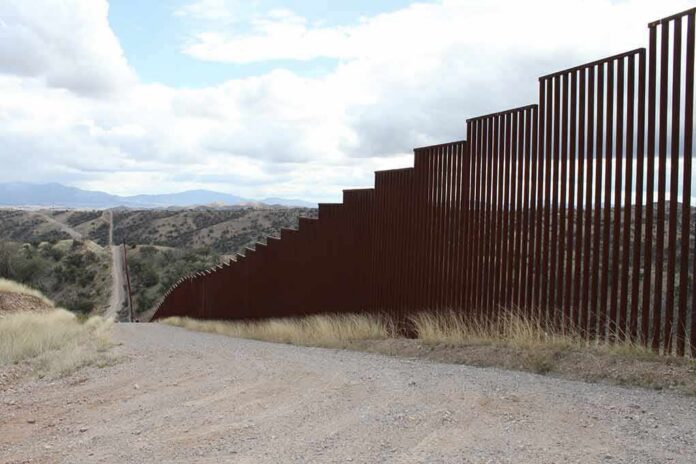shutterstock_1466093657 Border fence along a hilly landscape