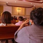 Sermon Splice Explodes Senate Race people seated in church pews facing a cross