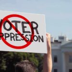 Nazi Tattoo Twist Explodes Senate Race Protester holding a sign in front of a government building