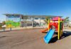 Playground with colorful slide in front of a school building