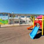 Playground with colorful slide in front of a school building