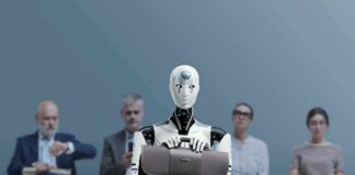 Jan-Peter Nikiferow seated with a humanoid robot holding a briefcase in front