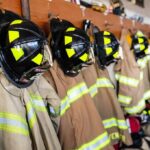 Firefighter helmets and turnout coats hanging on hooks