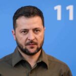 man in olive shirt against blue background