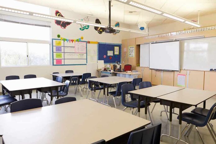 Empty classroom with tables, chairs, and a whiteboard