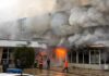 firefighters respond to large building fire with heavy smoke