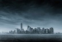 city skyline across water under overcast sky