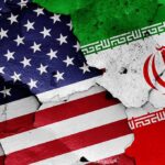 United States and Iran flags on cracked wall