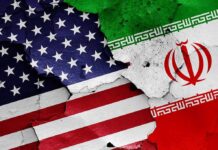 United States and Iran flags on cracked wall