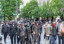 group of masked protesters walking through a city street