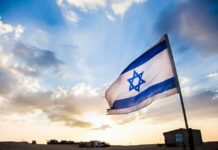 Israeli flag waving against a sunset backdrop with clouds