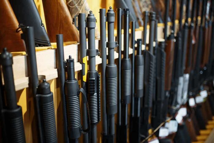 Shotguns and rifles lined up on a rack in a gun store