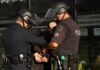 Police officers handcuff a person during an arrest