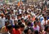 Crowd at a political rally with Kumar Gandharva, Ritu Rani, Jersson Vásquez, Mamata Banerjee, Pravin Amre, Sumrai Tete, Rangana Herath, and Gerson Torres