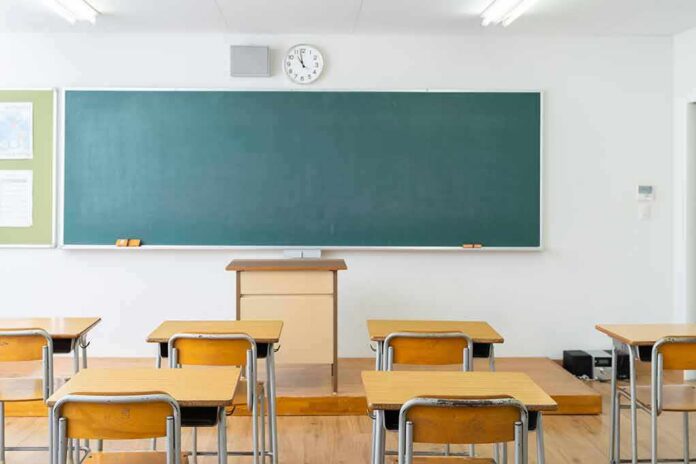 Empty classroom with desks facing a large chalkboard
